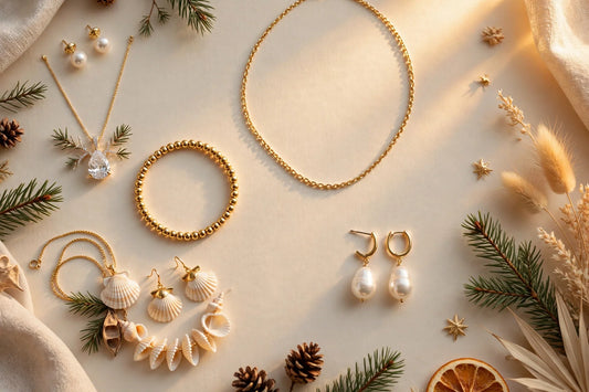 Christmas jewelry gifts for her flat-lay on a warm cream background with golden-hour glow