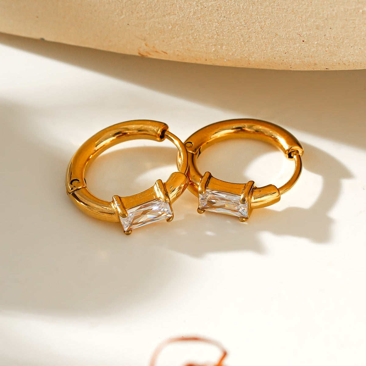 Style CONWYN: Retro Style Hoops with an Encased Clear Zirconia Charm in Gold.
